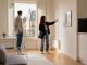 Jeune couple visitant un studio meublé lumineux à Paris, checklist en main