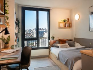 Studio étudiant lumineux avec bureau et vue urbaine pour la rentrée