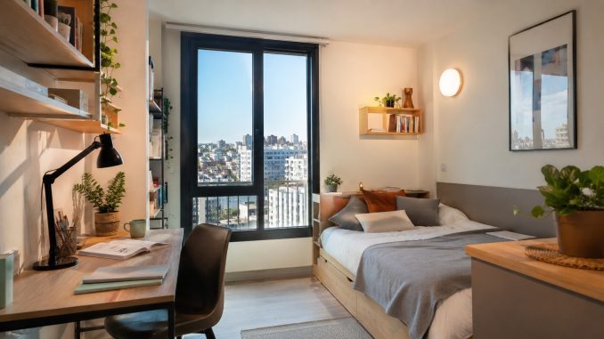 Studio étudiant lumineux avec bureau et vue urbaine pour la rentrée