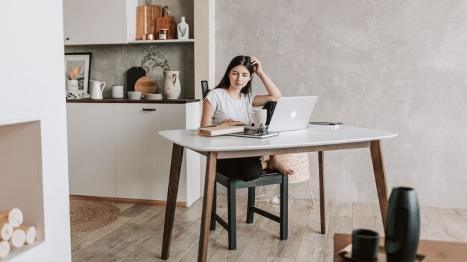 Etudiante travaillant sur son ordinateur dans son studio, calculant son budget avec les aides au logement 2026
